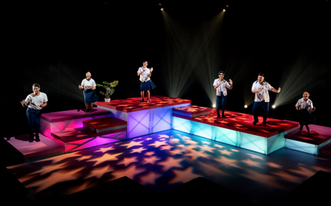 Image of all 6 cast members dancing on raised platforms