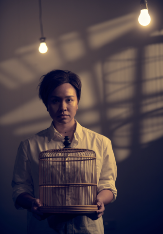 Oo-woo publicity photo with cast member Farah Lol holding an empty bird cage