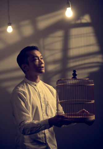 Oo-woo publicity photo with cast member Yazid Jalil holding an empty bird cage
